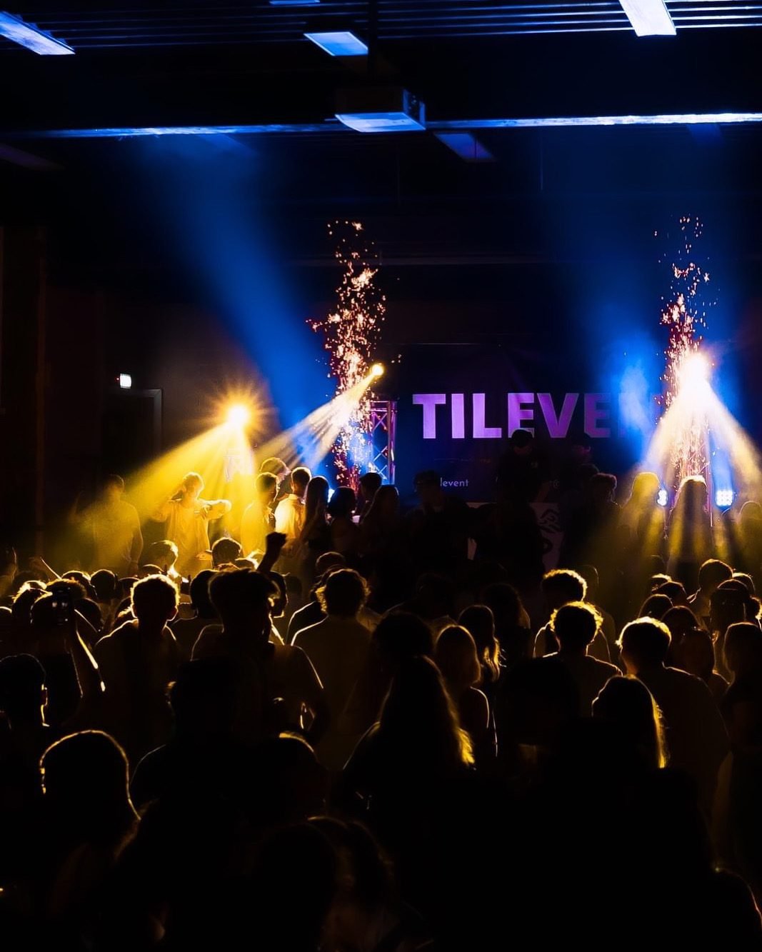 Ambiance festive avec spots LED colorés et machine à fumée pour soirée d'entreprise.